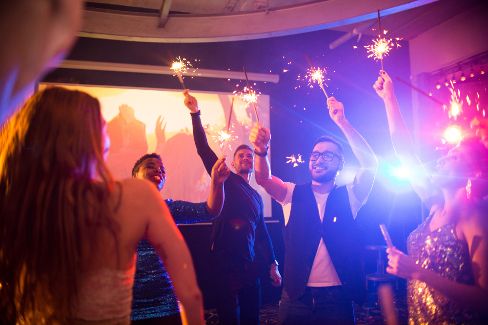Group of wedding guests holding sparklers, adding excitement to guest entertainment at wedding receptions.