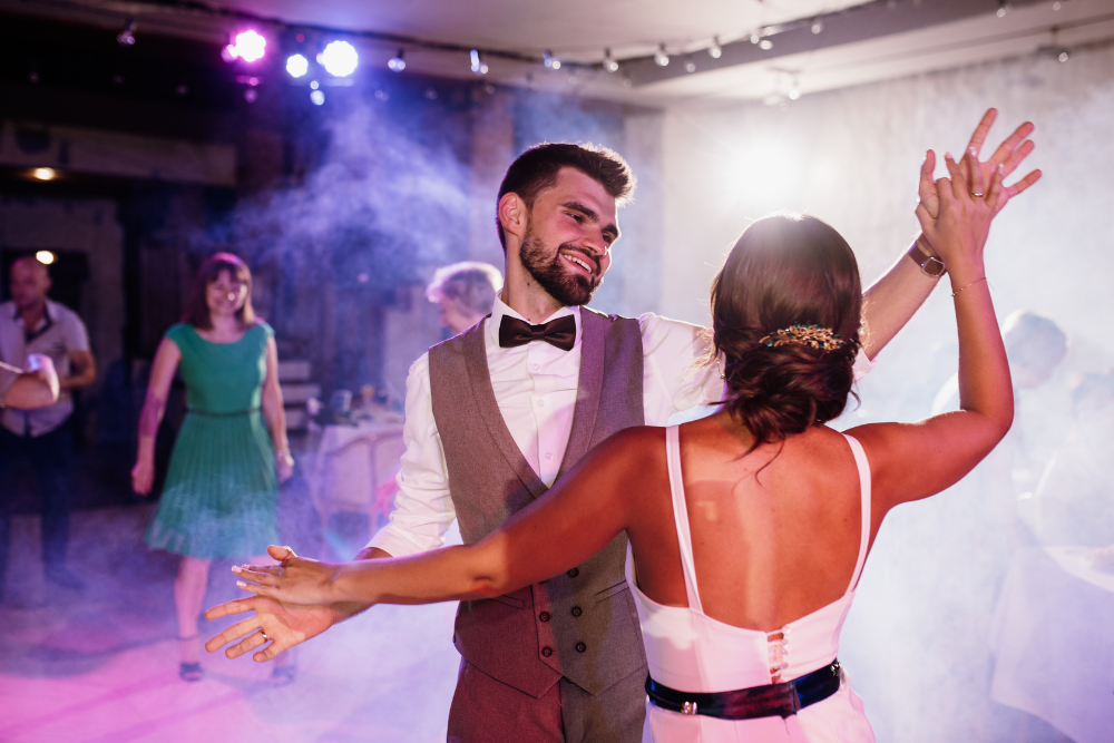 Bride and groom sharing their first dance while wedding guests watch and enjoy the moment.