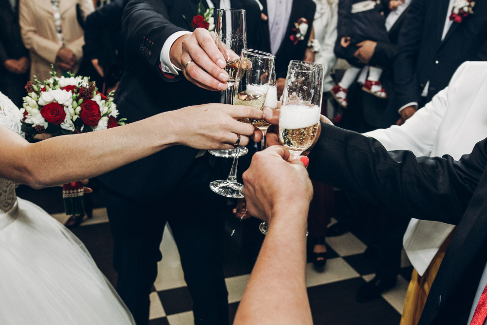 Guests raising champagne glasses for a wedding toast, marking a joyful moment of celebration