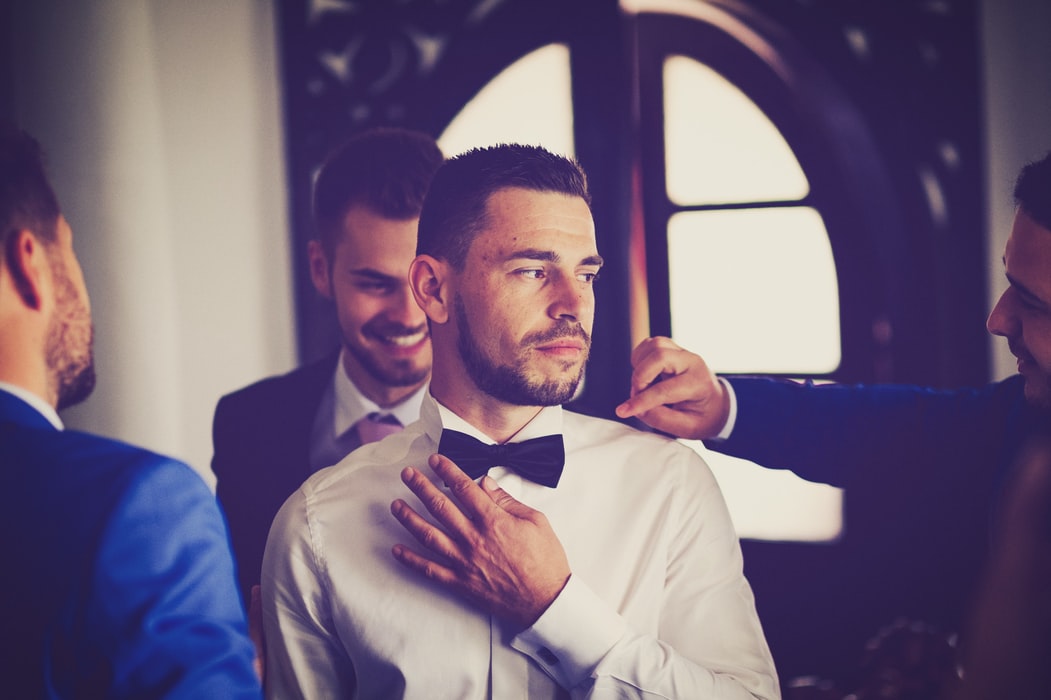 Wedding Day Tips For Groom - Groom Surrounded By Groomsmen