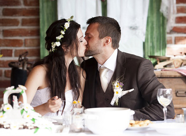 Brunette Bride And Groom Kissing At Wedding Celebration